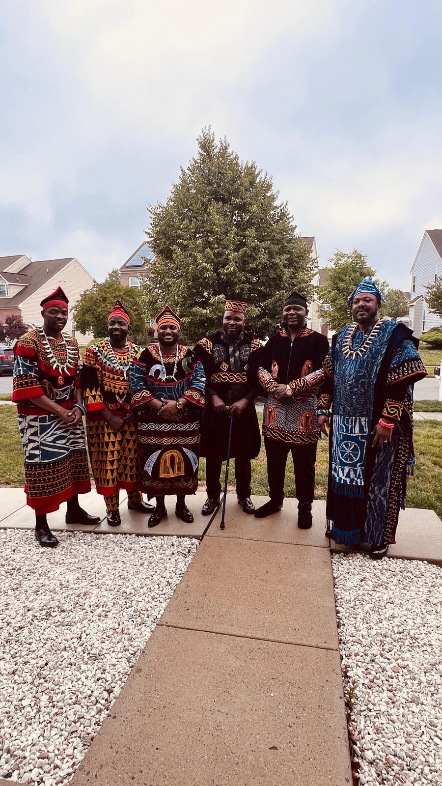 DEM USA members in traditional attire standing together outdoors